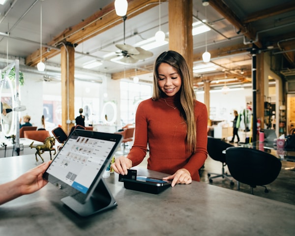 A local small business owner greeting a customer at checkout