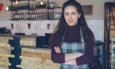 A local shop owner standing confidently in her storefront